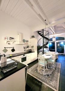 une cuisine blanche avec une table et un escalier en colimaçon dans l'établissement Katharinenhof App Loh, à Tönning