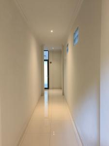 um corredor vazio com paredes brancas e pisos brancos em Pondok Bambu Homestay em Ubud