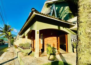 a house with a tree in front of it at Surfside Suites in Peruíbe