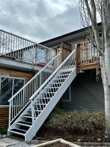 a white staircase on the side of a house at North Nanaimo Gem - Garden-View Room with Private Ensuite in Nanaimo