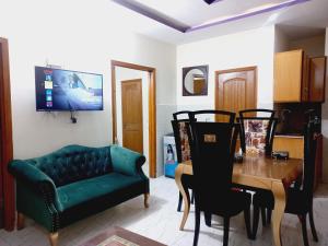 - un salon avec un canapé vert et une table dans l'établissement Haven Inn, à Lahore