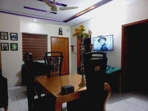 a dining room with a table and a ceiling fan at Haven Inn in Lahore