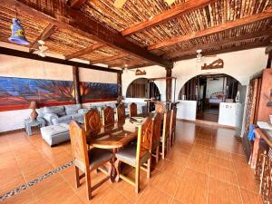 a dining room with a table and a couch at Chillaxing Beach Front House in Tulum