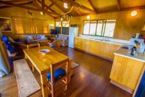 sala de estar con mesa de madera y cocina en Bimbimbi - Holiday hideaway by the bay of 1770 en Seventeen Seventy