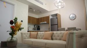 a living room with a couch and a kitchen at Chalet 2BR Duplex Apartment in Abu Dhabi