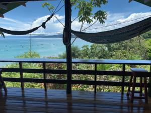 a hammock on a deck with a view of the ocean at VistaDrake Bungalow in Drake