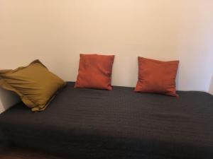 a bed with three pillows on top of it at ô vive studio in Monnetier-Mornex