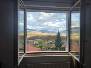 een raam in een kamer met uitzicht op een huis bij ô vive studio in Monnetier-Mornex