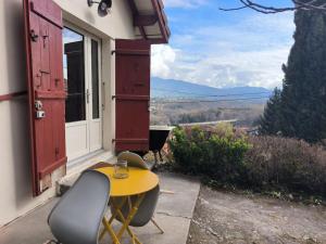 a yellow table and chairs on the porch of a house at ô vive studio in Monnetier-Mornex