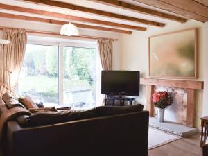 a living room with a couch and a large window at Mitsys Cottage in Darley
