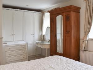a bedroom with a bed and a sink and a mirror at Mitsys Cottage in Darley