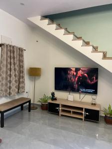 a living room with a flat screen tv on the wall at Party villa 4bhk in Bangalore