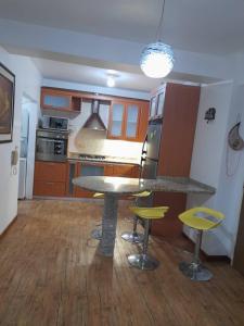 瓦倫西亞的住宿－Apartamento En Valencia，厨房配有桌子和一些黄色的椅子