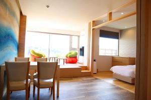 a dining room with a table and chairs and a bedroom at Toba Grand Hotel in Toba