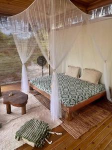 sypialnia z łóżkiem z zasłonami i stołem w obiekcie Casa Maiara (Eco friendly) w mieście Morere