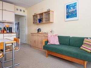 a living room with a green couch and a kitchen at 4 person holiday home in Fanø-By Traum in Fanø +24 photos