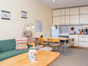 a living room with a couch and a table and a kitchen at Holiday home Fanø VII in Fanø