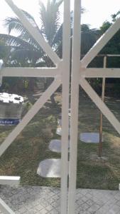 a view of a garden through a white fence at LaMaison in Ocho Rios