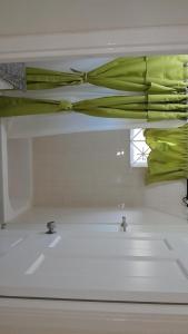 baño con lavabo y cortina verde en LaMaison, en Ocho Ríos