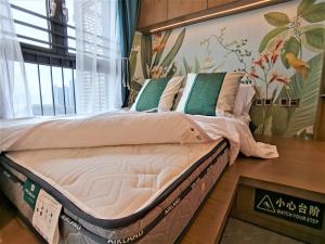 uma cama num quarto com uma parede com flores em Interact China Fine Condo - Shenzhen Bay em Shenzhen