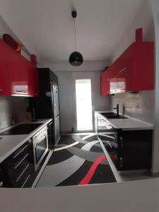 クシロカストロにあるSea Front Luxury Maisonetteの黒と白のフロアのキッチン(赤いキャビネット付)