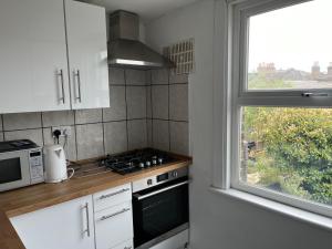 a kitchen with a stove top oven next to a window at shardeloes in London