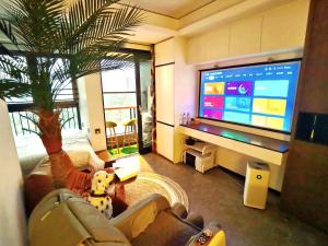 een woonkamer met een bank en een grote tv bij Interact China Fine Condo - Shenzhen Bay in Shenzhen