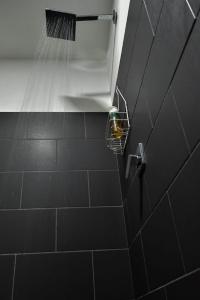 ducha con cabezal de ducha y cesta en la pared en Epimoni, en Poás