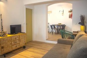 a living room with a couch and a tv on a cabinet at Casa da Maria in Évora