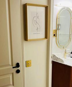 ein Badezimmer mit einem Waschbecken, einem Spiegel und einer Tür in der Unterkunft Villa Tropez in Saint-Tropez