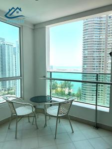 a table and chairs in a room with a large window at Mansion One in George Town