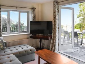 a living room with a couch and a flat screen tv at Bron Madog in Mynfford