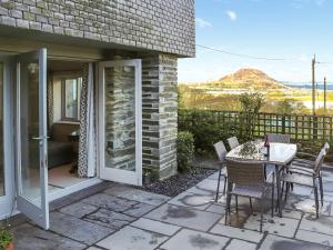 a patio with a table and chairs with a view at Bron Madog in Mynfford