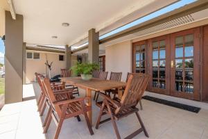 a dining room with a wooden table and chairs at Your Home at Southside Central - Family friendly. in Bundaberg