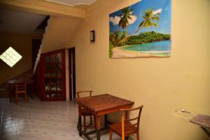 a dining room with a table and a painting on the wall at Rusara Villa in Tissamaharama