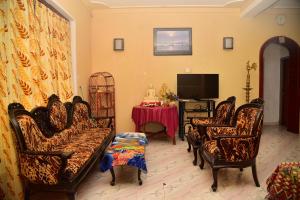 a living room with chairs and a tv and a table at Rusara Villa in Tissamaharama