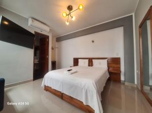um quarto com uma cama grande e um cobertor branco em Hotel Betania em Jaén