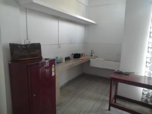 a kitchen with a refrigerator and a table in a room at Moa's Nest in Dimāpur