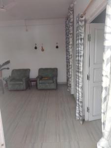 - un salon avec deux chaises et une porte dans l'établissement Moa's Nest, à Dimāpur