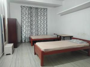 um quarto de hospital com duas camas e uma janela em Moa's Nest em Dimāpur