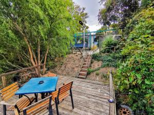 a blue table and benches on a wooden deck with a train at Vila lac lll in Năvodari