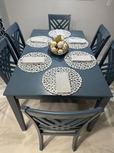 una mesa azul con platos blancos y un bol de fruta en Home Away From Home, en Vero Beach