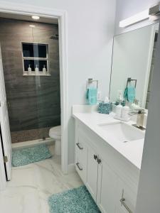 a bathroom with a sink and a toilet and a mirror at Home Away From Home in Vero Beach