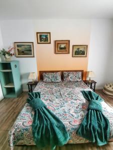 a bedroom with a bed with two mitts at Vila lac lll in Năvodari