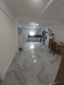 a large white room with a kitchen and a table at Masfol comfort house in Oldham