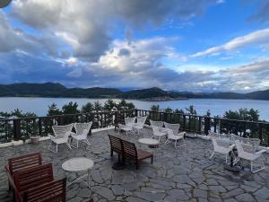 a group of chairs and tables on a patio near the water at Country House Exclamation Mark & Comma in Namhae