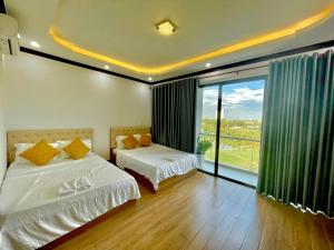 1 dormitorio con 2 camas y ventana grande en KHÁCH SẠN HỒ GIA VILLA Phan Rang, en Kinh Dinh