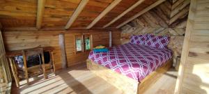 a bedroom with a bed in a log cabin at Cabaña Lato_puzhio in Chordeleg