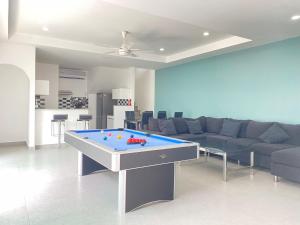 south pattaya,5BR modern villa في باتايا سنترال: غرفة معيشة مع أريكة وطاولة بلياردو