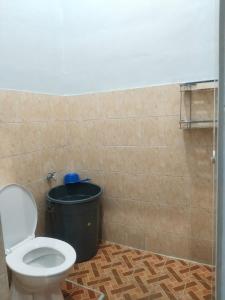 a bathroom with a toilet and a trash can at Rome Residence Sibolga Pandan in Halangan